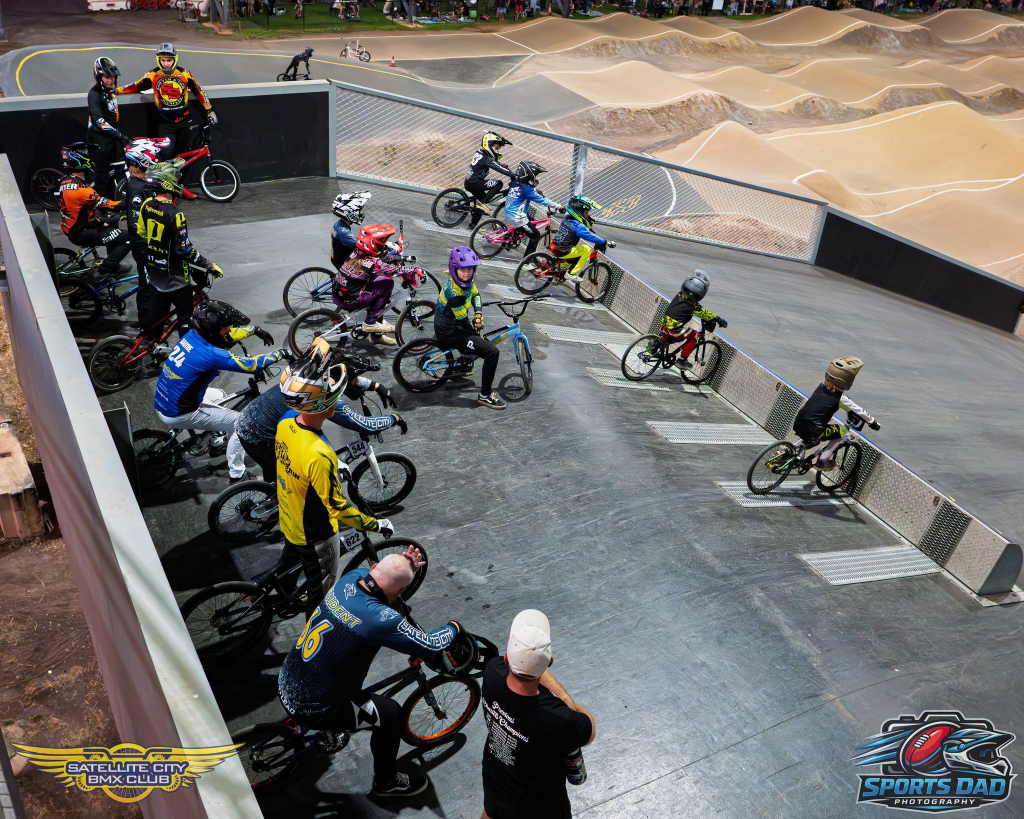 BMX rider in yellow and purple gear racing the track